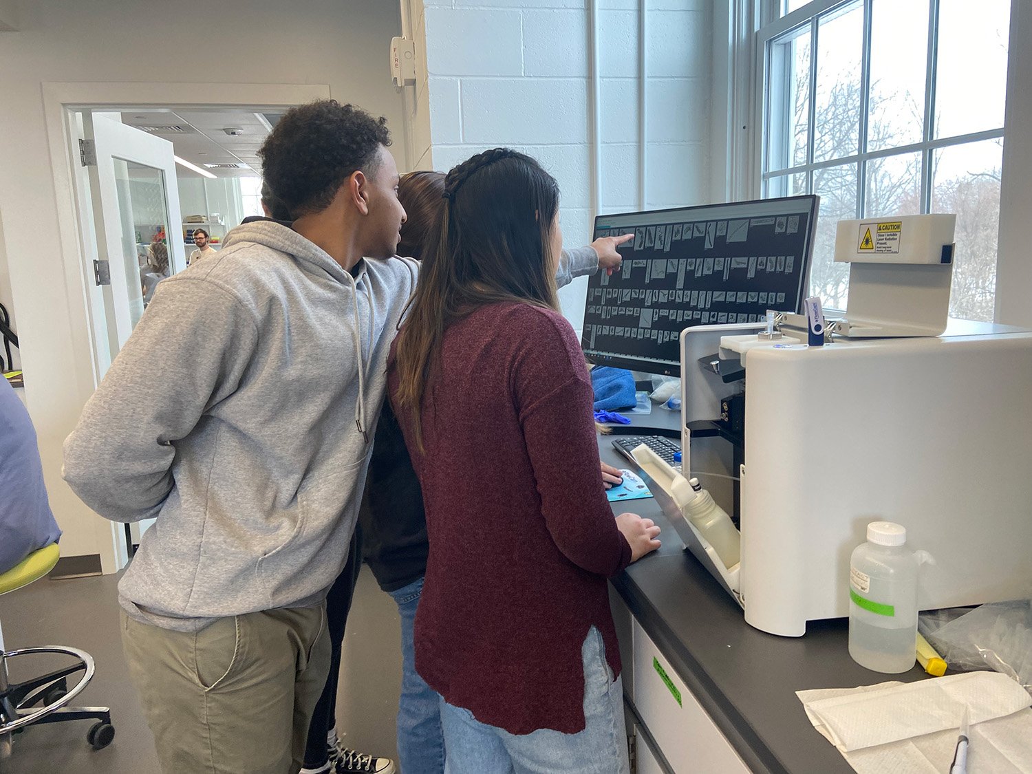 Students looking at monitor, pointing to images