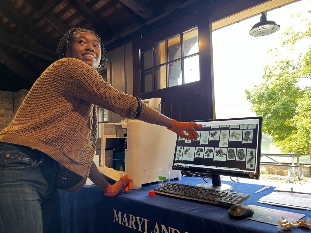 Woman pointing at screen with FlowCam images of algae